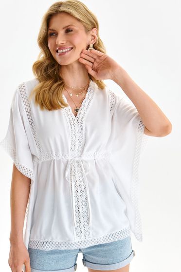 White women`s blouse light material loose fit with butterfly sleeves is fastened around the waist with a ribbon